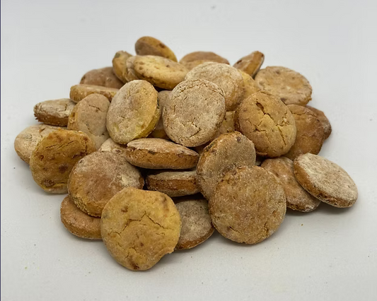 Stack of round brown dog treats on a white background